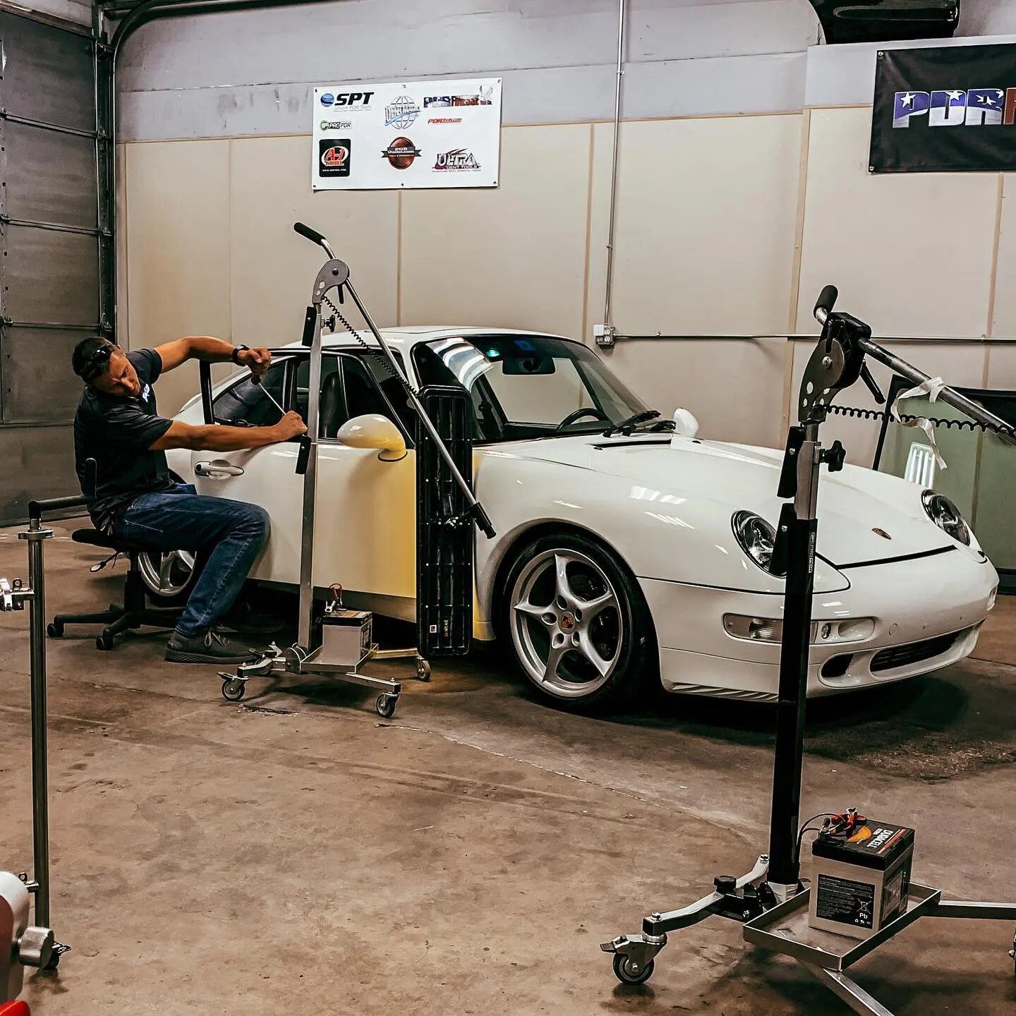 Founder inspecting a repaired luxury vehicle panel at the Plano shop